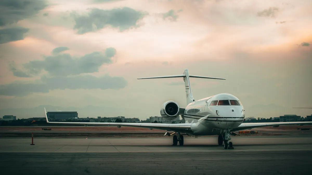 Long-range business jet parked on the ramp under a soft evening sky